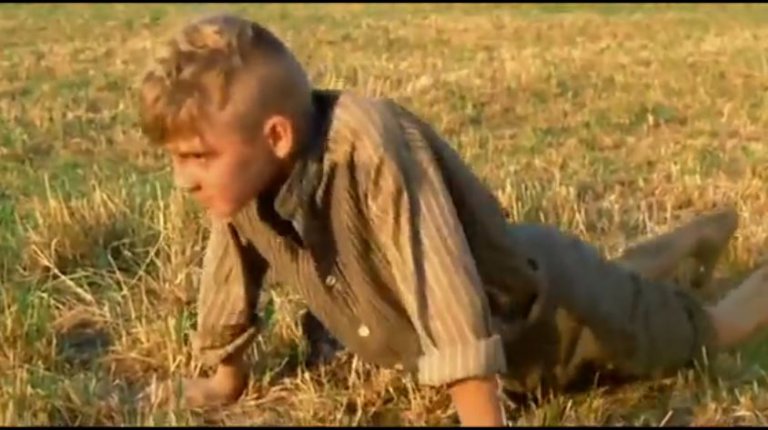 Le jeune acteur Roberto Maccanti − dans le rôle d'Olmo enfant − mimant un coït anal avec la terre, dans le film 1900 de Bernardo Bertolucci (1976).